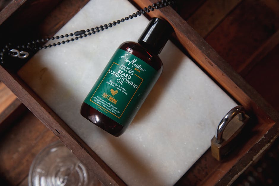 10 Best Beard Oils for Seborrheic Dermatitis in 2023: Our Top Picks - Beard conditioning oil bottle on a rustic wooden tray with a lock and chain, top view.