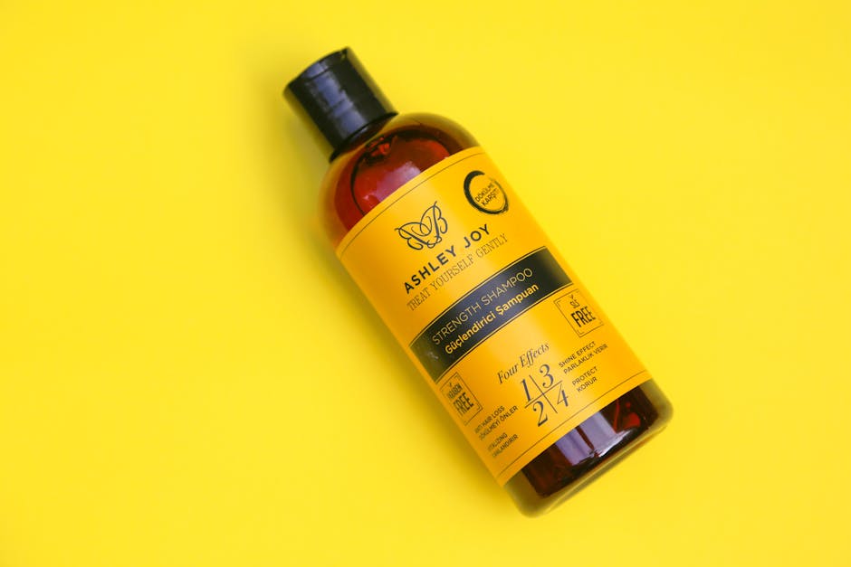 10 Best Seborrheic Dermatitis Shampoos - Top view of Ashley Joy Strength Shampoo with vibrant yellow background.