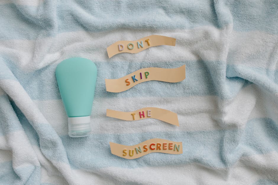 Best Sunscreen for Seborrheic Dermatitis: Safe SPF That Won't Trigger Flare-Ups (2026) - Flat lay of sunscreen bottle with message 'Don't skip the sunscreen' on a towel.