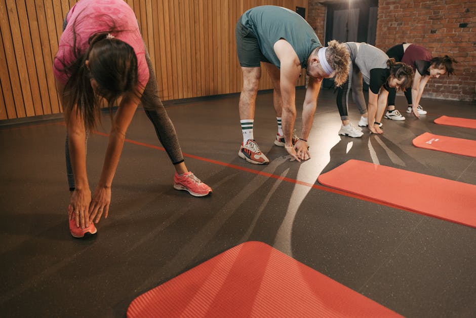 Best Sweat-Wicking Products for Seborrheic Dermatitis in Summer 2026 - A diverse group of adults stretching on mats during a gym workout session.