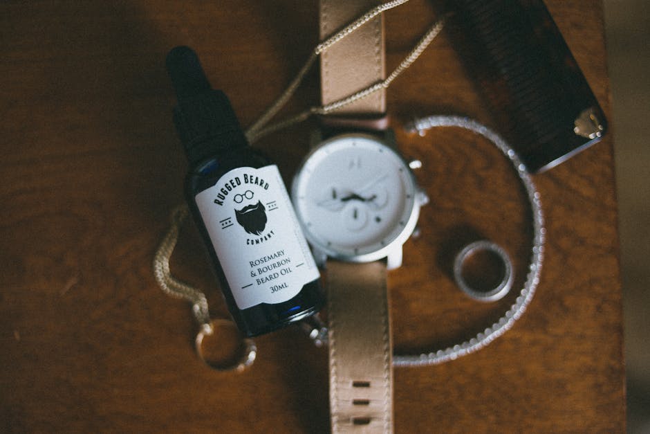 Can Oily Skin Really Cause Seborrheic Dermatitis? Here's What You Need to Know - Stylish flatlay featuring beard oil, watch, and jewelry on a wooden table.