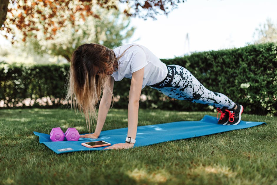 Complete Summer Seb Derm Survival Guide: Heat, Sweat & Humidity Management - Woman doing push-ups on a yoga mat outside with dumbbells and a smartphone nearby.