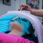 Discover Effective Phototherapy Techniques for Seborrheic Dermatitis - Unrecognizable woman with dark hair with pierced ears lying under ultraviolet lamp while visiting contemporary clinic and spending time in modern salon