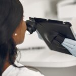 Exploring Topical Calcineurin Inhibitors for Seborrheic Dermatitis Relief - Dermatologist examining a patient's skin using a digital dermatoscope and tablet for precision observation.