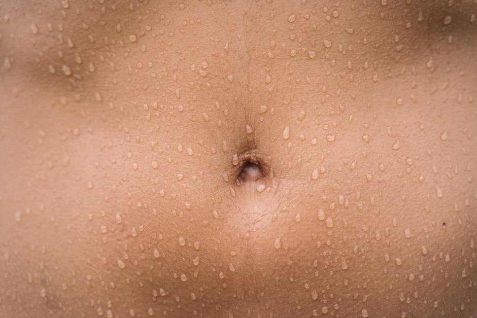 How Seborrheic Dermatitis Impacts Skin Barrier Function: A Comprehensive Analysis - A detailed close-up image of a human belly with water droplets on the skin, showcasing texture.