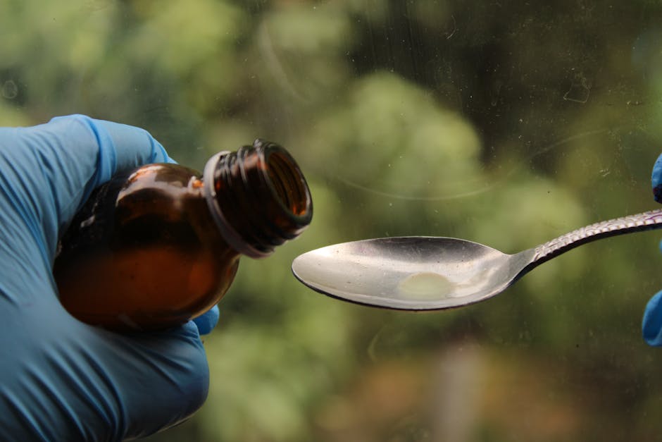 Luliconazole Shampoo for Seborrheic Dermatitis: What Research Shows (2026) - Close-up of syrup being poured from a bottle into a spoon by gloved hands, medical concept.
