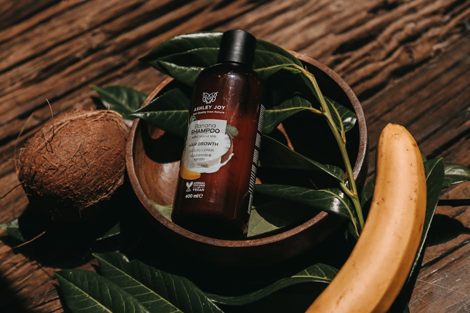 Luliconazole Shampoo for Seborrheic Dermatitis: What Research Shows (2026) - Natural shampoo bottle surrounded by banana and coconut on wooden surface.