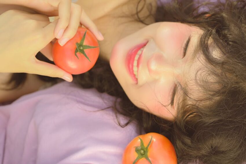 Managing Seborrheic Dermatitis: Unveiling the Diet Link for Relief - Smiling woman enjoying a sunny day with ripe tomatoes outdoors.