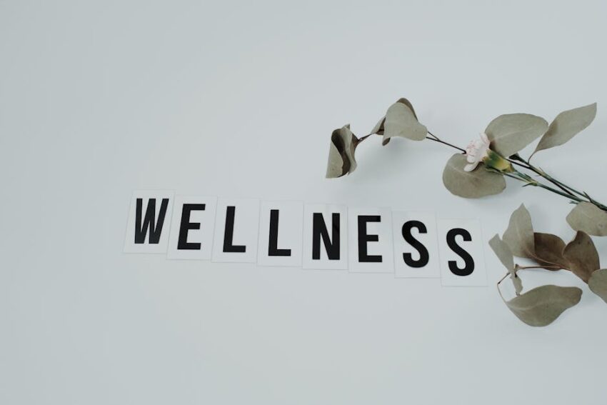 Overview - Minimalist image of the word 'wellness' with eucalyptus branch, creating a serene vibe on white background.