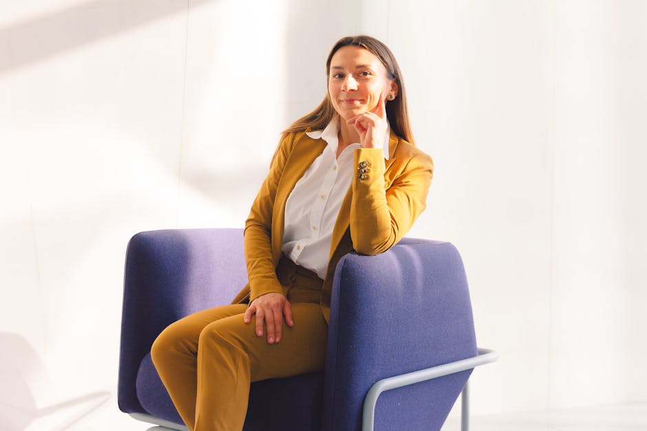 Salicylic Acid for Seborrheic Dermatitis: Does It Work? (2026 Guide) - A stylish woman in a brown suit sits confidently in a modern office chair with a bright smile.