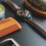 Seborrheic Dermatitis and Curly Hair: Scalp Care Guide for Tight Coils and Waves (2026) - Flat lay image of grooming items with an elegant leather wristwatch on a dark surface.