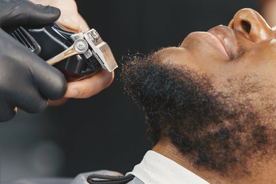 Seborrheic Dermatitis and Curly Hair: Scalp Care Guide for Tight Coils and Waves (2026) - A detailed close-up of a barber trimming a beard, showcasing grooming techniques.