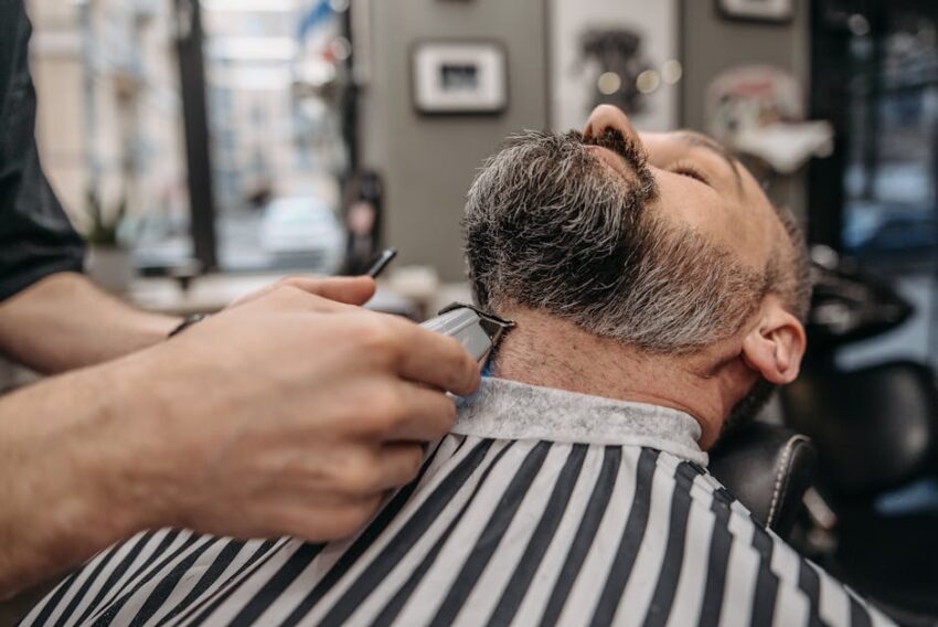 Seborrheic Dermatitis and Face Oils: Which Oils are Safe and Which Trigger Flares? (2026) - Close-up of a professional barber trimming a man's beard in a stylish barbershop.