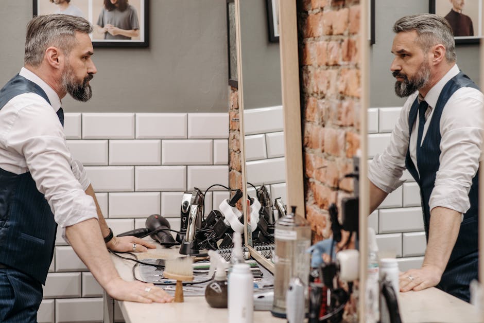 Seborrheic Dermatitis and Face Oils: Which Oils are Safe and Which Trigger Flares? (2026) - A bearded gentleman examines his reflection in a stylish barbershop setting.