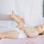 Seborrheic Dermatitis in Infants - A tender moment with a baby receiving a gentle massage on a bed.