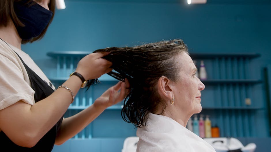 Seborrheic Dermatitis or Dry Scalp? How to Tell the Difference (2026) - An elderly woman enjoying a stylish hair treatment by a professional hairstylist in a salon.
