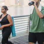 Seborrheic Dermatitis Self-Care: Daily Routines, Home Remedies & Lifestyle Tips - A couple engages in fitness walking by the riverside, embodying a healthy lifestyle.