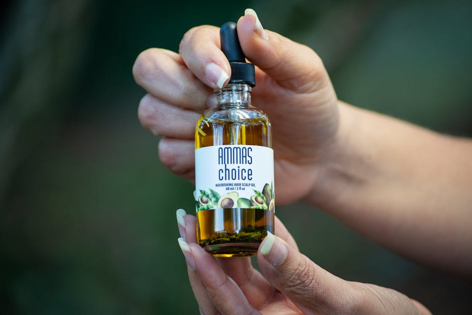 Seborrheic Dermatitis vs Dry Scalp on the Face: How to Tell the Difference - Close-up of hands holding a hair scalp oil bottle.