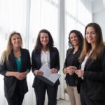 Sulfur for Seborrheic Dermatitis: Does This Classic Treatment Still Work? (2026 Guide) - Four professional women in business attire smiling in a bright, modern office.