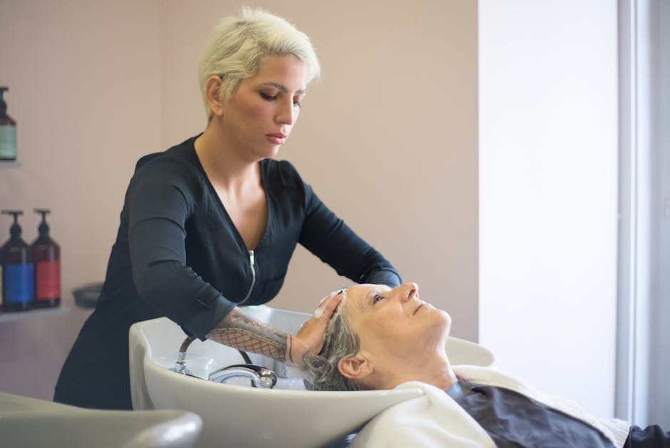 Swimming with Seborrheic Dermatitis? Learn How Chlorine Can Affect Your Skin and Hair - A hairdresser providing a relaxing hair wash to a senior woman in a salon setting.