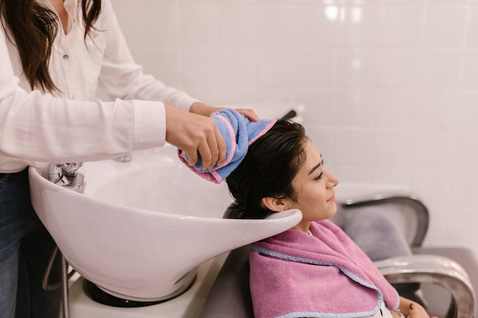 Swimming with Seborrheic Dermatitis? Learn How Chlorine Can Affect Your Skin and Hair - A woman enjoys a relaxing hair wash at a modern hair salon, emphasizing self-care and pampering.