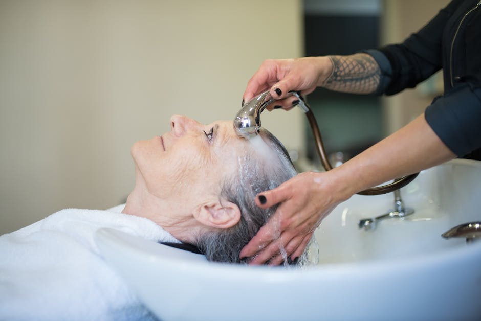 Swimming with Seborrheic Dermatitis? Learn How Chlorine Can Affect Your Skin and Hair - Elderly woman receiving a relaxing hair wash in a salon setting.