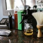 Tea Tree Oil for Seborrheic Dermatitis: Does It Work? Evidence-Based Guide 2026 - Close-up of barber tools on counter including clippers, spray bottle, and brush in a stylish barbershop.