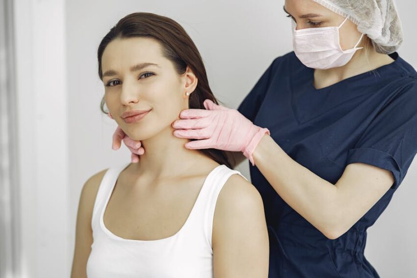 The pH Connection: How Balancing Your Skin's pH Can Help Treat Seborrheic Dermatitis - A medical practitioner in scrub suit performs a neck examination on a smiling woman in a clinic.