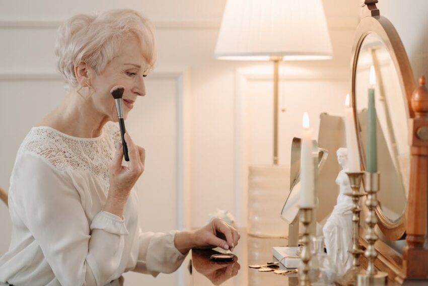 Why Seborrheic Dermatitis Keeps Coming Back: Managing the Relapse Cycle (2026) - Elderly woman using makeup brush at dresser by candlelight.
