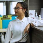 Zinc Pyrithione Soap for Seborrheic Dermatitis: Does It Work? (2026 Guide) - Side view of an Asian woman in a modern office environment, displaying professional demeanor.