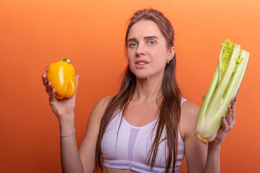 Can Diet Affect Seborrheic Dermatitis? What 2026 Research Shows - Woman holding yellow bell pepper and celery, showcasing healthy eating.