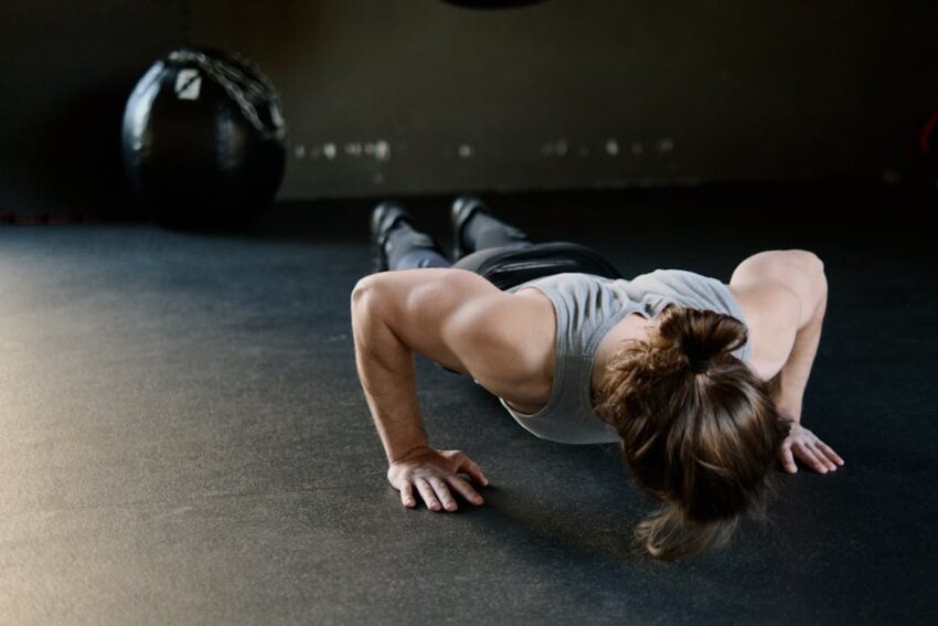 Can Exercise Help Prevent Seborrheic Dermatitis? What 2026 Research Suggests - Strong male engaged in push-up exercise on gym floor, showcasing upper body strength.