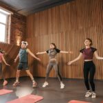 Can Exercise Help Prevent Seborrheic Dermatitis? 2026 Research - Group of adults doing jumping jacks in modern gym interior.