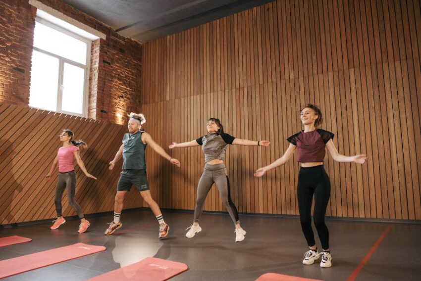 Can Exercise Help Prevent Seborrheic Dermatitis? 2026 Research - Group of adults doing jumping jacks in modern gym interior.