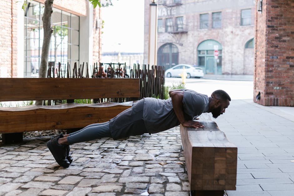 Can Exercise Help Prevent Seborrheic Dermatitis? What 2026 Research Suggests - Fit man doing push-ups on a bench in an urban outdoor setting, focusing on fitness and healthy lifestyle.