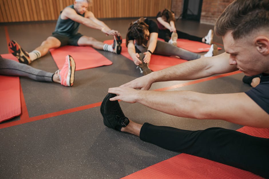 Can Exercise Help Prevent Seborrheic Dermatitis? 2026 Research - Adults participating in fitness stretching session indoors, enhancing flexibility on red yoga mats.