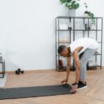 Can Exercise Prevent Seborrheic Dermatitis? What the 2026 Research Shows - Black man practicing yoga indoors with mat, promoting healthy lifestyle and body care.