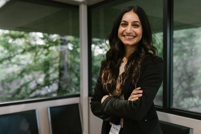 Do Antihistamines Work for Seb Derm? 2026 - Smiling woman in business attire stands confidently in a modern office with large windows.