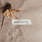 seb-derm-vs-demodex-mites-2026 - A dried flower beside a handwritten well-being note on brown paper, evoking calmness and reflection.
