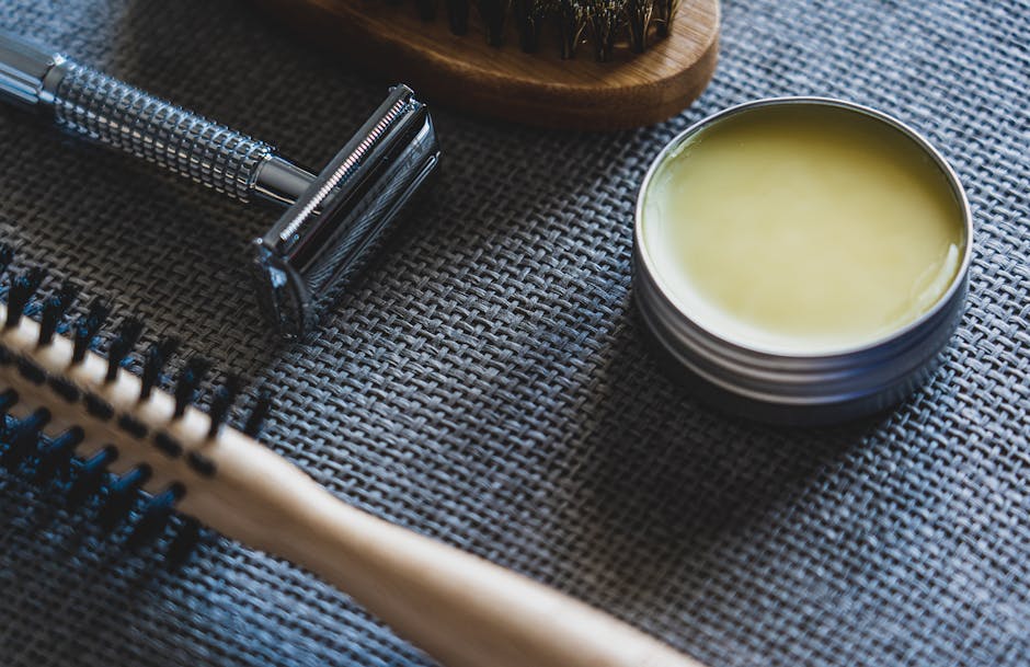 seborrheic-dermatitis-beard-treatment-guide-2026 - A flat lay of grooming tools including a razor, brush, and pomade on a textured surface.