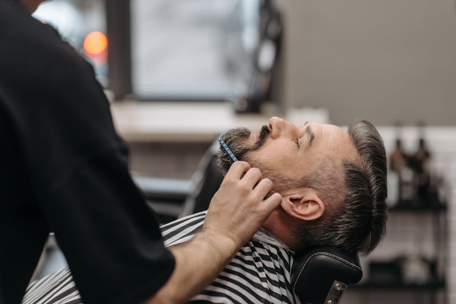 seborrheic-dermatitis-beard-treatment-guide-2026 - Close-up of a barber styling a man's beard in a modern salon, showcasing grooming techniques.