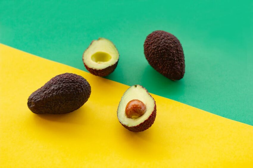 seborrheic-dermatitis-diet-guide-2026 - Ripe avocados displayed on vibrant green and yellow background, perfect for culinary themes.