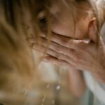 seborrheic-dermatitis-face-treatment-guide-2026 - A woman splashes water on her face, emphasizing refreshing skincare routine.