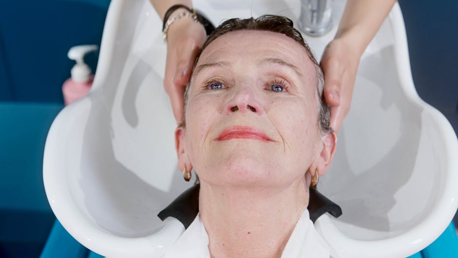 seborrheic-dermatitis-hair-loss-treatment-regrowth-2026-final - An elderly woman getting a hair wash at a salon, enjoying a relaxing grooming service.