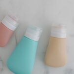 Seborrheic Dermatitis or Dry Scalp? How to Tell the Difference Before You Buy Another Shampoo - Three colorful squeezable bottles with flip tops on a marble surface.