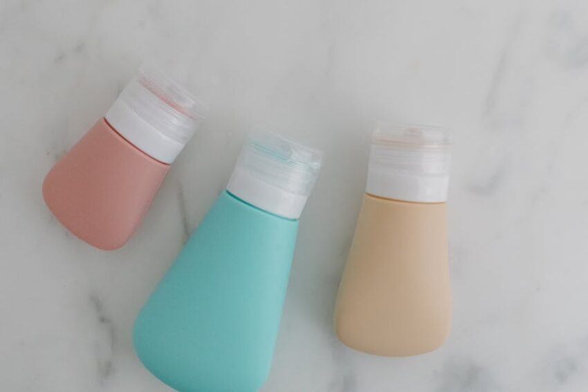 Seborrheic Dermatitis or Dry Scalp? How to Tell the Difference Before You Buy Another Shampoo - Three colorful squeezable bottles with flip tops on a marble surface.