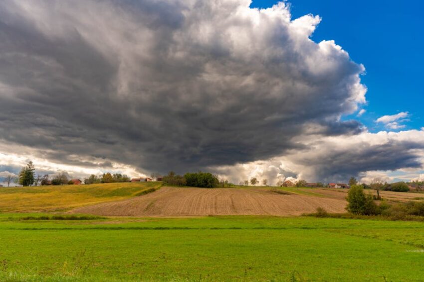 summer-emergency-seb-derm-flare-care-quick-relief-strategies-2026 - A picturesque rural landscape with dramatic storm clouds gathering over green fields and farmland.